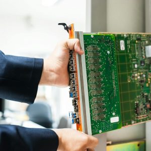 A technician inserts a circuit board into a server rack, illustrating technology and connectivity.